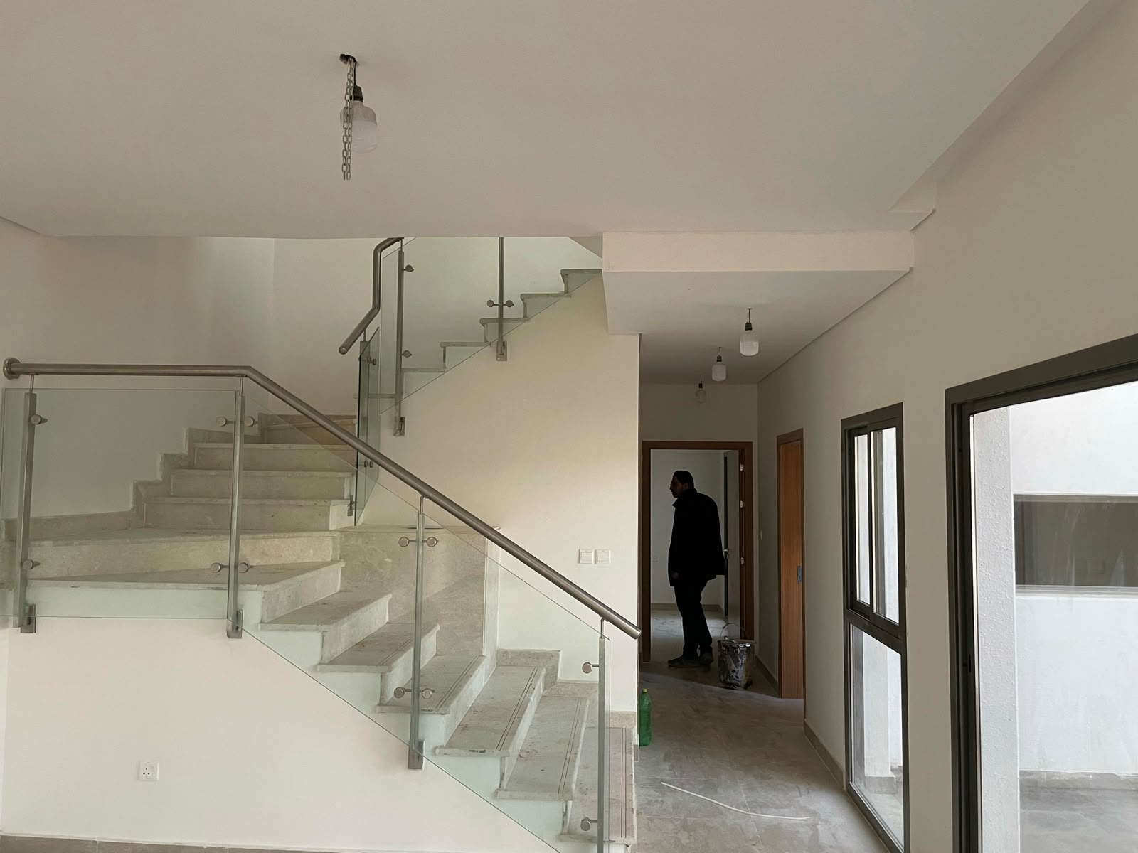 Finished villa interior with glass-railed staircase